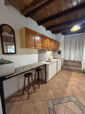 a kitchen with wooden cabinets and two stools in it at Settebello - Antica Mangiatoia Palermitana in Palermo