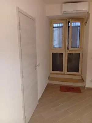 a room with a door and two windows at Casetta Professa Centro in Palermo