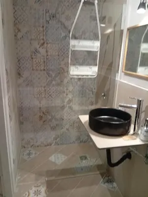 a bathroom with a shower with a black sink at Casetta Professa Centro in Palermo