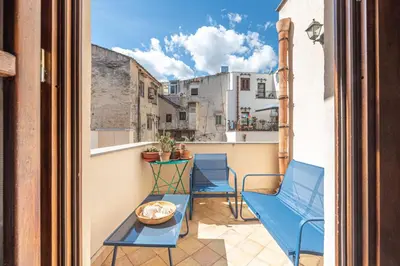 a balcony with blue chairs and a table at San Salvatore Apartment by Wonderful Italy in Palermo