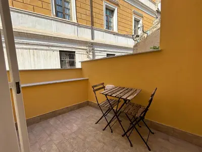 a table and chairs on the balcony of a building at Dimora Santa Spina in Palermo