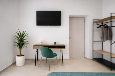 a room with a desk and a green chair at A' meusa Palermo Historic Center Check-in 24h in Palermo