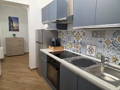 a kitchen with a table with two chairs and a microwave at Marèa in Porticello