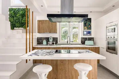 a kitchen with a white counter and stools at Elegant Villa With Pool Luxury in Carini