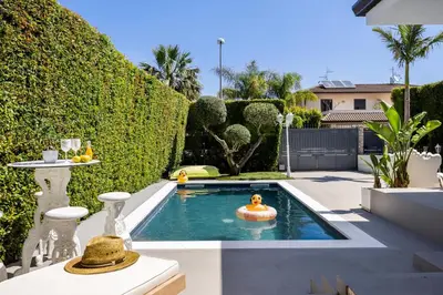 a backyard with a pool with a man in a ball in the water at Elegant Villa With Pool Luxury in Carini