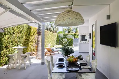 a patio with a table and chairs and a television at Elegant Villa With Pool Luxury in Carini