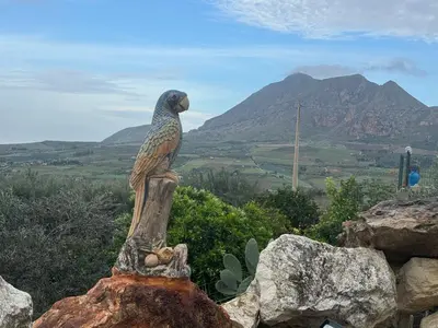 a statue of a bird sitting on top of a rock at Villa Liliana in San Giuseppe Jato