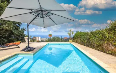 a swimming pool with an umbrella and a swimming pool at Amazing Home In Caccamo in Caccamo