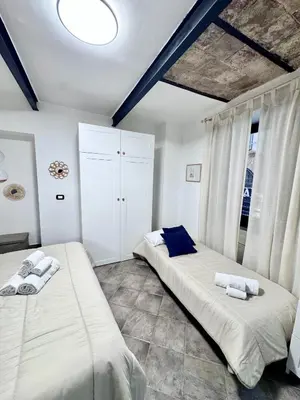 a bedroom with two beds and a large window at Nel Cuore del Capo in Palermo