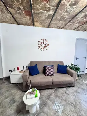 a living room with a brown couch and blue pillows at Nel Cuore del Capo in Palermo