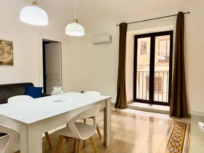 a dining room with a white table and chairs at Dimora Sant'Agostino in Palermo