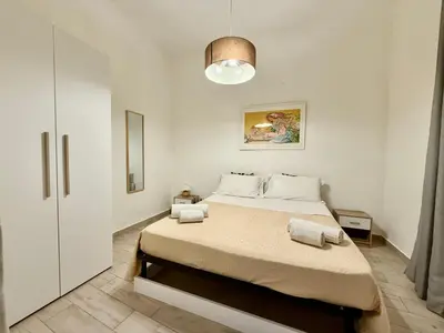 a white bedroom with a bed with towels on it at Dimora Sant'Agostino in Palermo