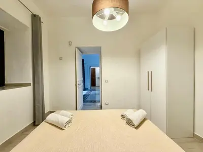 a bedroom with a large bed and a light fixture at Dimora Sant'Agostino in Palermo