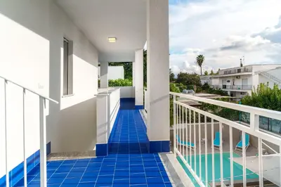 a bathroom with a white sink and blue tiles at Luxury apartment Villa Vera Mondello - Palermo in Mondello