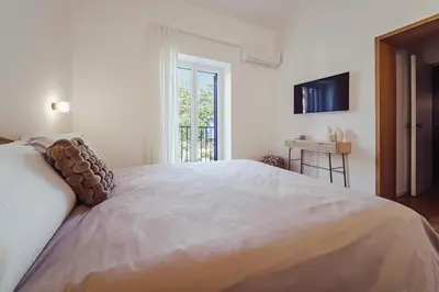 a white bedroom with a large bed and a window at Seasicily Boutique Apartment in Palermo