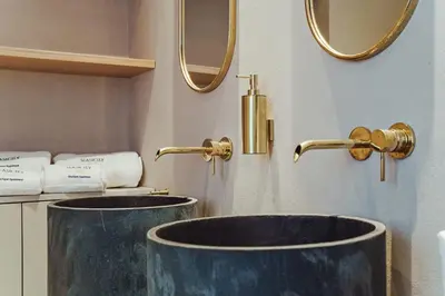 a bathroom with two sinks and gold faucets at Seasicily Boutique Apartment in Palermo