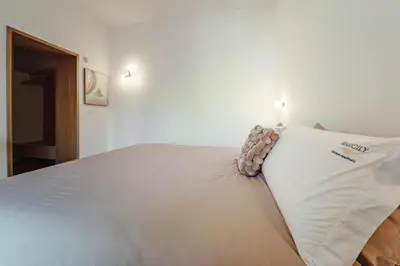 a white bed with a pillow on top of it at Seasicily Boutique Apartment in Palermo