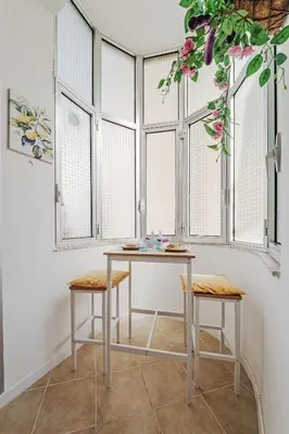 a table and two stools in a room with windows at CastroViva House in Palermo