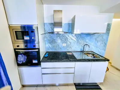 a small kitchen with a sink and a microwave at Sunset in Santa Flavia