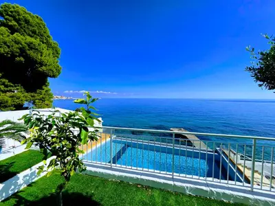 a swimming pool with the ocean in the background at Pearl in Santa Flavia