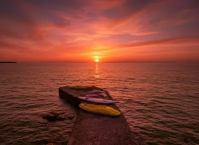 a yellow kayak on a pier in the ocean at sunset at Pearl in Santa Flavia