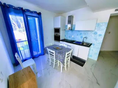 a kitchen with a table and chairs in a room at White Coral in Santa Flavia