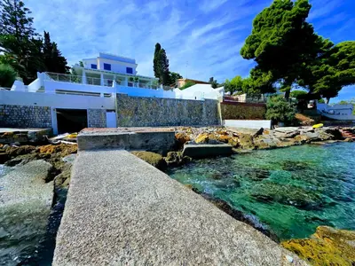 a house on the shore of a body of water at White Coral in Santa Flavia