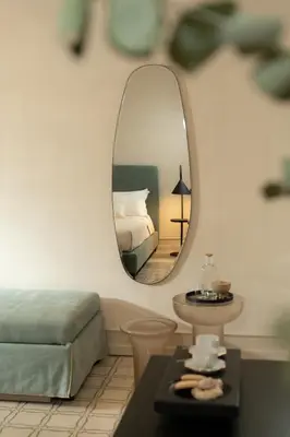 a living room with a bed and a mirror at Palazzo Balsamo Boutique Hotel in Palermo