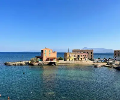 a small island in the middle of a body of water at Al Baglio di Sant'Elia in Santa Flavia
