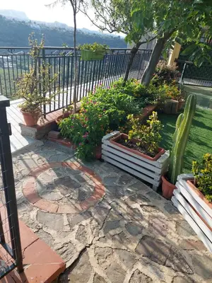a patio with a bunch of plants and a fence at Casetta Giardinetto in Altavilla Milicia