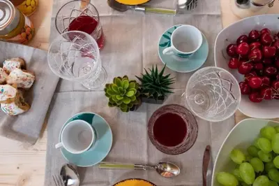 a table with cups and plates of food and fruit at Casa Duci - Historic center in Palermo