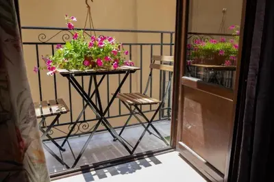 a balcony with two baskets of flowers on a railing at Casa Duci - Historic center in Palermo