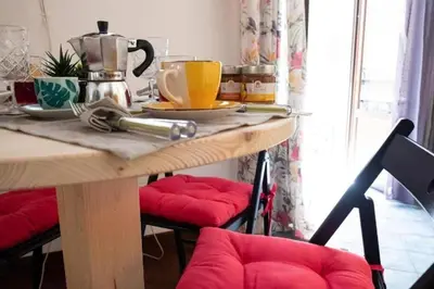 a wooden table with red cushioned chairs in a kitchen at Casa Duci - Historic center in Palermo