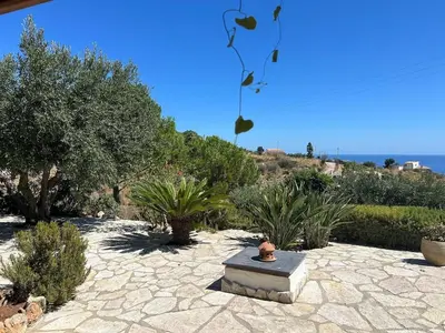 a garden with a stone bench and plants at A Casuzza di Poggio Scopello in Scopello