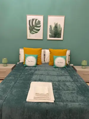 a bedroom with a large green bed with pillows at Casa Amuri in Palermo