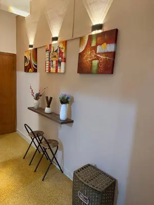 a room with a table and chairs and paintings on the wall at Casa Amuri in Palermo