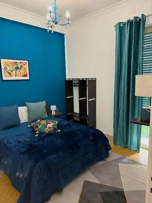 a bedroom with a blue wall and a bed at Casa Amuri in Palermo