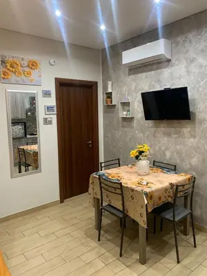 a dining room with a table with chairs and a tv at Girasole Marino in Palermo