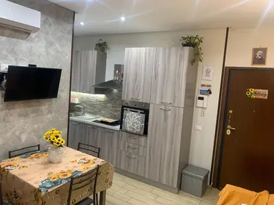 a kitchen with a table and a kitchen with a counter at Girasole Marino in Palermo