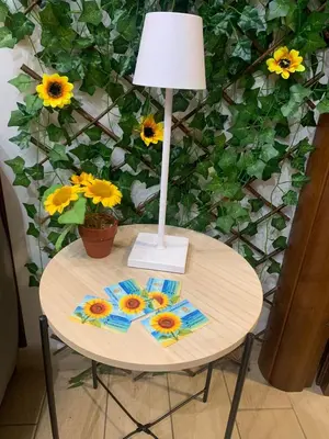 a table with a lamp and sunflowers on it at Girasole Marino in Palermo