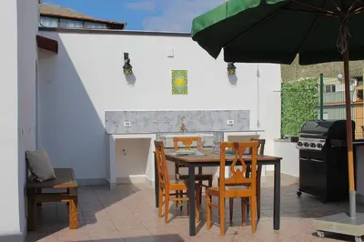 a patio with a table and chairs and an umbrella at Esperia Home in Palermo