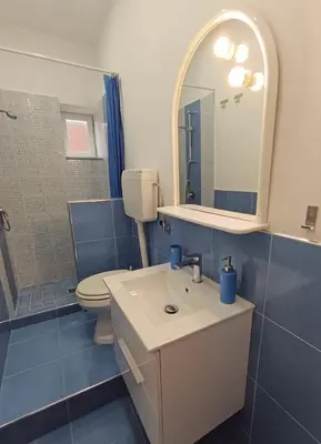 a bathroom with a sink and a toilet and a mirror at Esperia Home in Palermo
