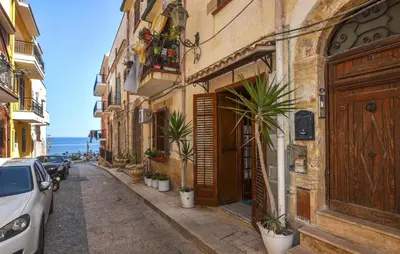 a narrow street with buildings and potted plants at Cozy Apartment In Trappeto With Wifi in Trappeto
