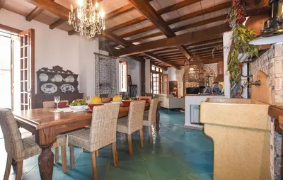 a kitchen and dining room with a wooden table and chairs at Cozy Apartment In Trappeto With Wifi in Trappeto