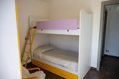 a small bedroom with a bunk bed and a ladder at Villa Verde - Nature Holiday Home in Carini
