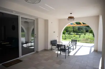 a dining room with an archway and a table and chairs at Villa Verde - Nature Holiday Home in Carini