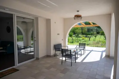 a dining room with an archway and a table and chairs at Villa Verde - Nature Holiday Home in Carini