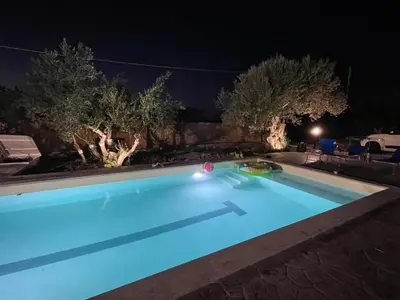 a swimming pool lit up at night at Villa Verde - Nature Holiday Home in Carini