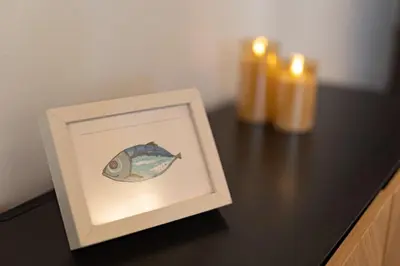 a picture of a fish on a table with two candles at Cathedral Apartment - Stay in Palermo in Palermo
