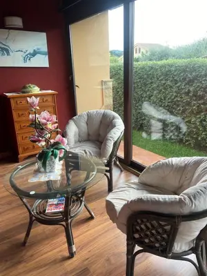 a living room with two chairs and a glass table at Il Giardino di Seba in Campofelice di Roccella